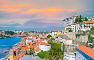 Cityscape panorama of Porto at sunset with colorful traditional buildings along the Douro River, highlighting historic architecture and scenic views in Portugal