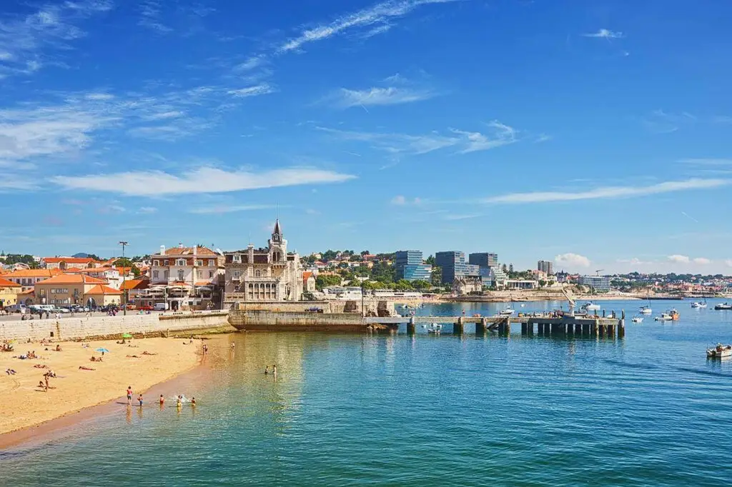 Scenic view of Estoril beach and waterfront with historic buildings and blue sea in Portugal