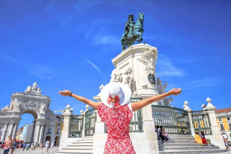 Tourist enjoying Praça do Comércio square in Lisbon Portugal with the Arco da Rua Augusta and King José I statue on a sunny day