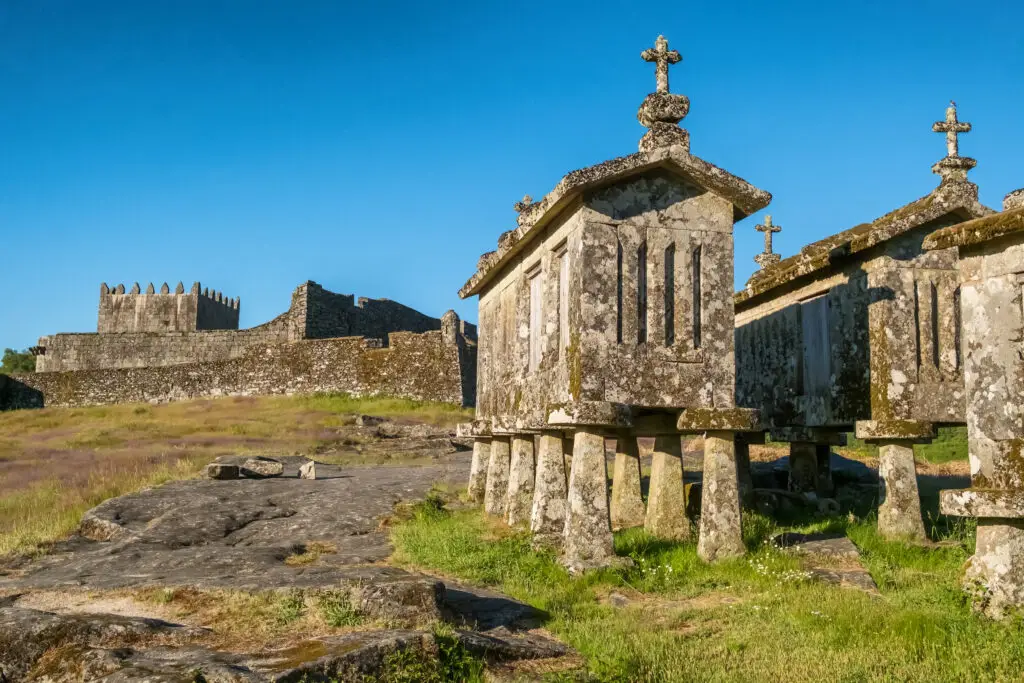 Traditional stone granaries of Lindoso village with Lindoso Castle in the background, a historical landmark and popular tourist attraction in northern Portugal