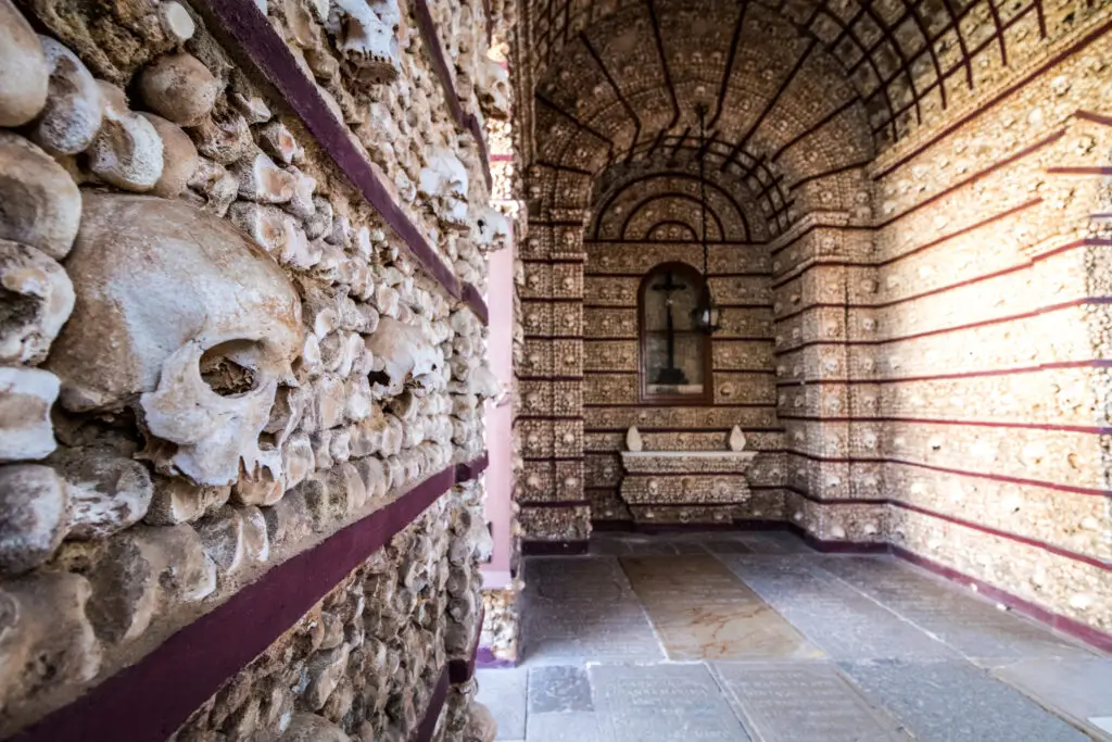 Interior of the Bone Chapel in Faro Portugal featuring walls decorated with human skulls and bones, a historic and unique cultural attraction popular for private tours