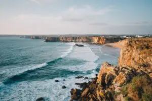 Scenic view of Tonel Beach with rocky cliffs, ocean waves, and golden coastline in Sagres, Algarve, Portugal