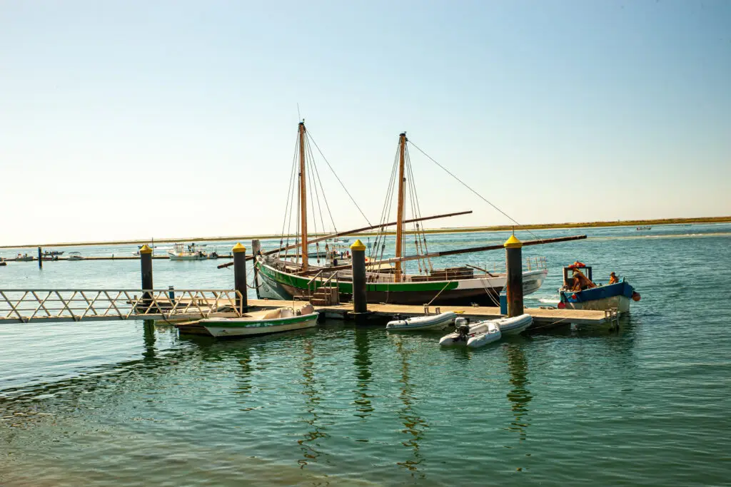 Traditional fishing boats moored at the harbor in Olhão, Algarve, Portugal, on a sunny day showcasing coastal tourism and maritime culture