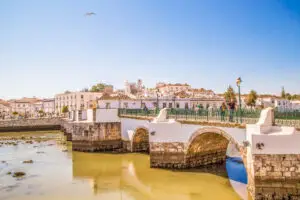 Historic Roman Bridge and old town architecture in Tavira, Algarve, Portugal on a sunny day, popular sightseeing location for Private Portugal Tours