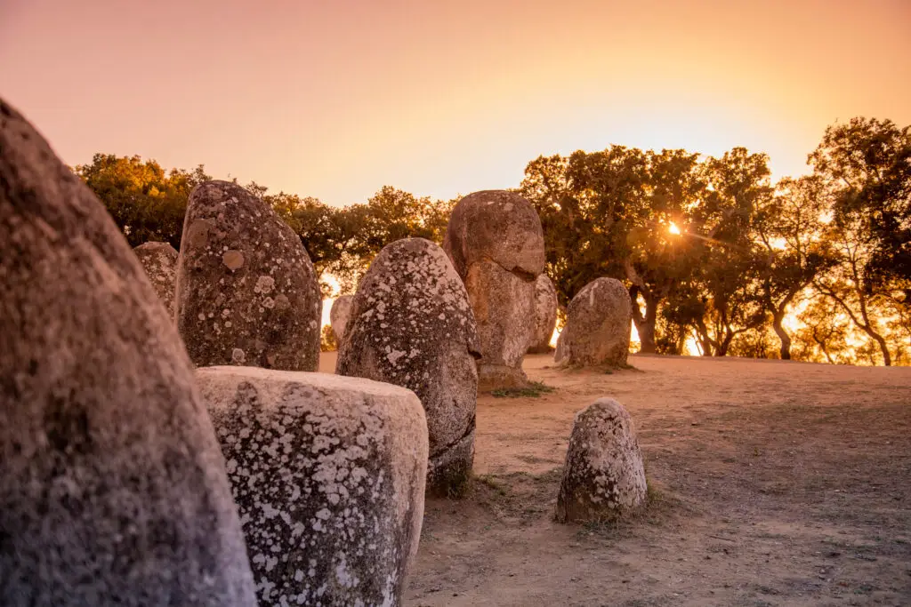 Ancient stone megaliths at Almendres Cromlech near Évora in the Alentejo region of Portugal at sunset, a popular historical site for Private Portugal Tours