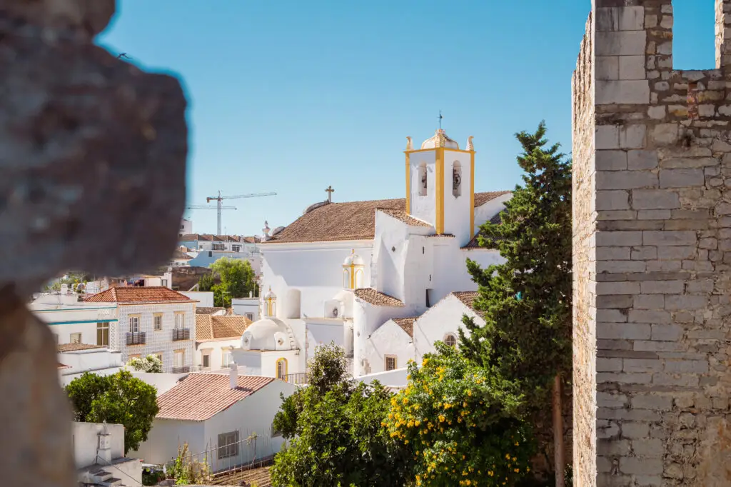 View of the Church of Tavira from the Castle in Algarve Portugal with whitewashed buildings and clear blue sky