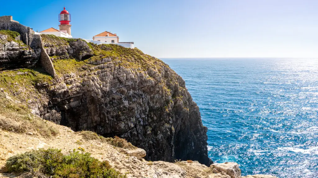 Farol do Cabo de São Vicente lighthouse perched on the rugged cliffs overlooking the Atlantic Ocean at Cabo de São Vicente, Algarve, Portugal