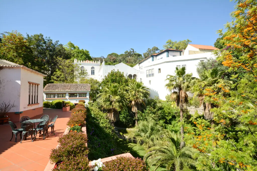Health resort of Caldas de Monchique in Algarve Portugal surrounded by lush gardens, palm trees, and traditional white buildings under a clear blue sky