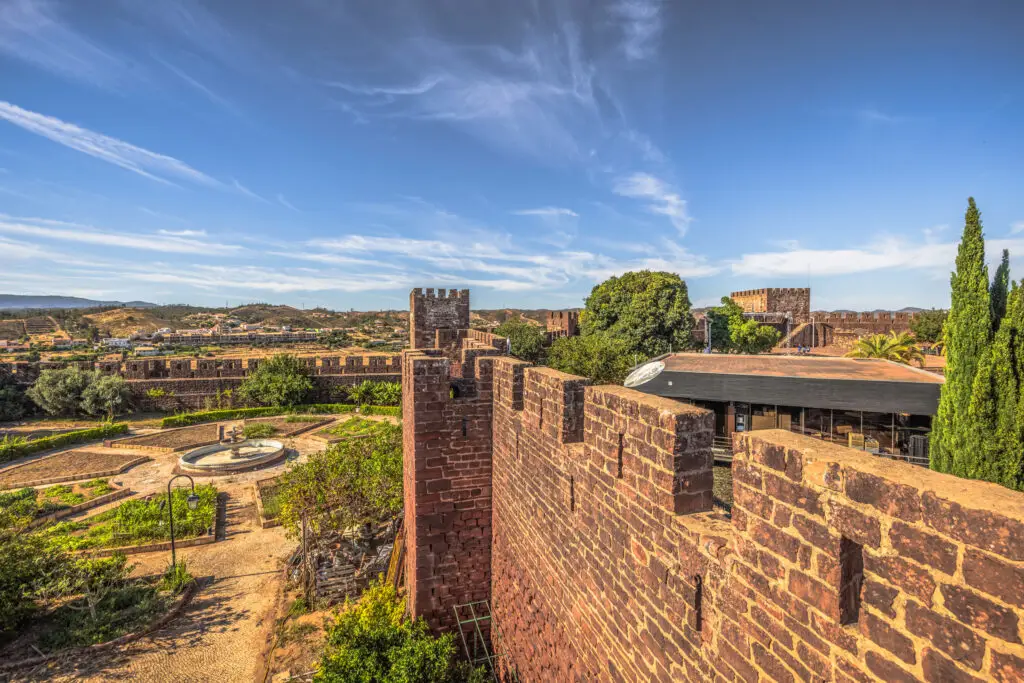 Medieval Castle of Silves in Portugal with ancient red stone walls, scenic gardens, and panoramic views of the Algarve countryside