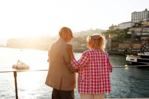Mature couple enjoying a romantic sunset view over the Douro River in Porto Portugal during a private sightseeing tour