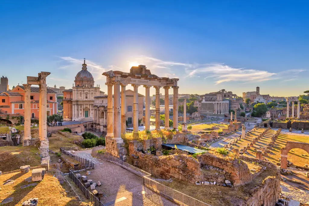Sunrise over the ancient ruins of the Roman Forum in Rome Italy showcasing historic columns and city skyline