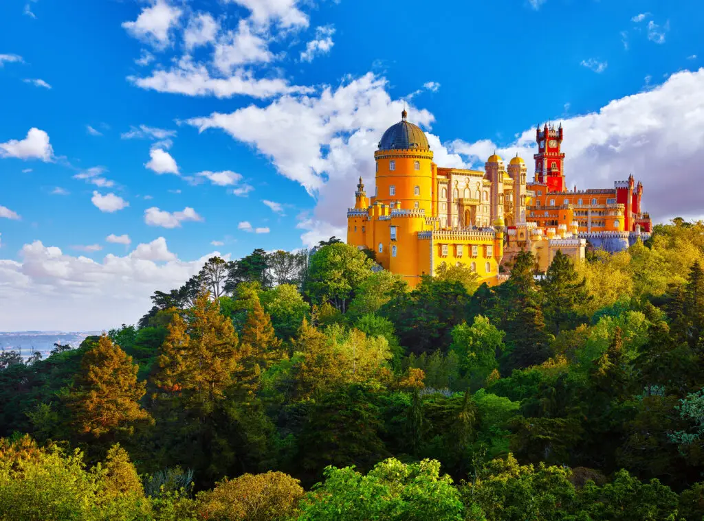 Colorful view of the Palace of Pena in Sintra, Lisbon, Portugal, a famous landmark surrounded by lush green forest and blue sky
