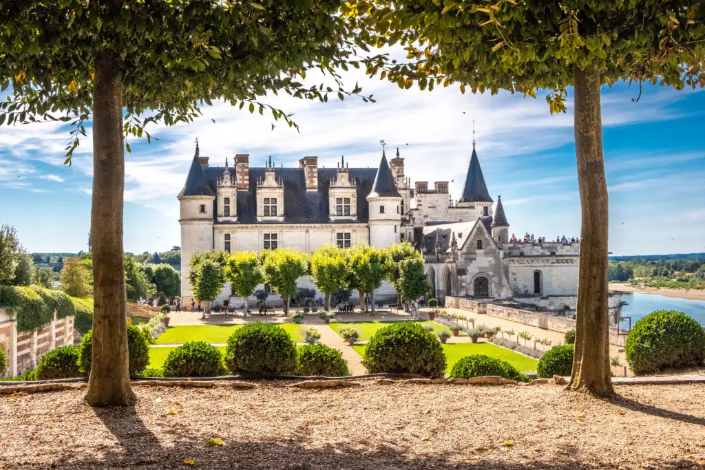 Château d’Amboise in France framed by trees and Renaissance gardens overlooking the Loire River, a popular European heritage site and tourist attraction