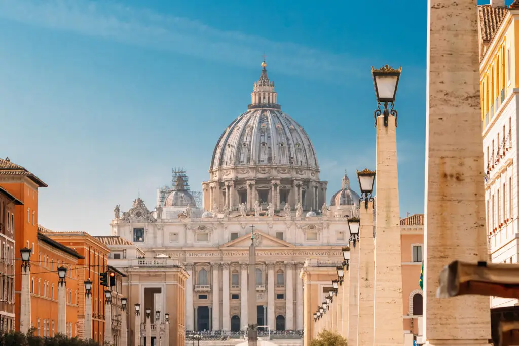 St. Peter’s Basilica and St. Peter’s Square in Vatican City, Rome, Italy with historic architecture and clear blue sky, popular tourist attraction near the Vatican