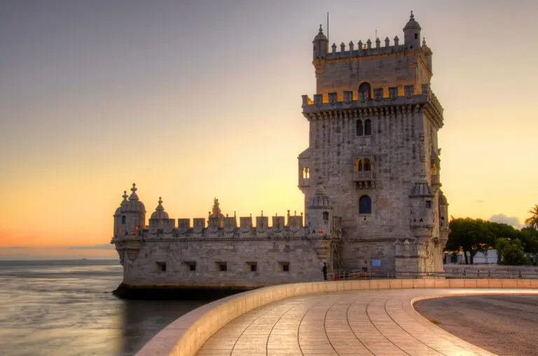 Belem Tower at sunset in Lisbon Portugal with golden sky reflecting on the Tagus River, a famous historic landmark and popular tourist attraction