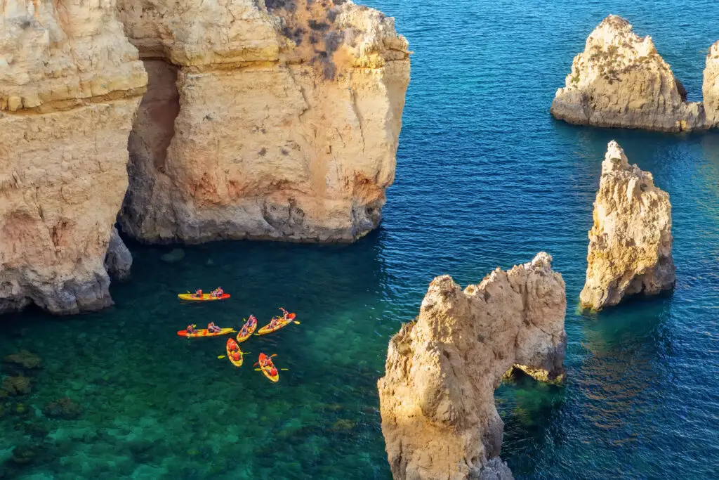 Aerial view of kayakers exploring the turquoise waters and rocky cliffs of Ponta da Piedade in Lagos, Algarve, Portugal coast