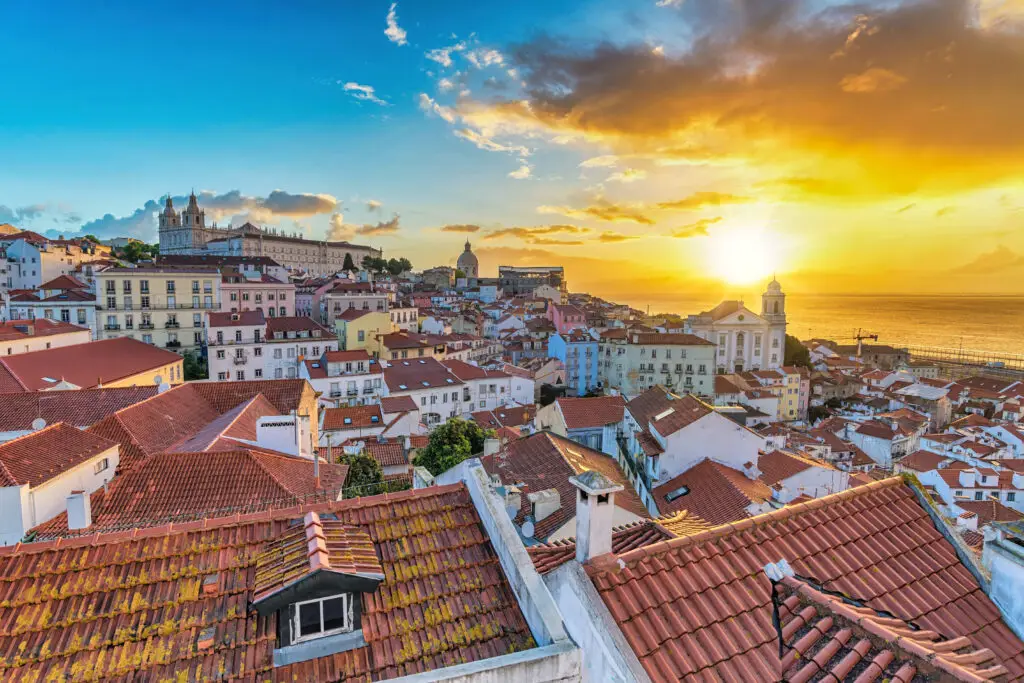 Lisbon Portugal sunrise city skyline over Alfama district with colorful historic buildings and Tagus River view