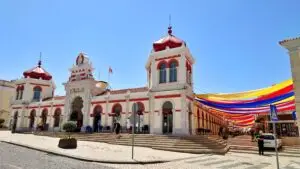 Marché de Loulé in Portugal featuring the iconic red and white market building with colorful canopy decorations, a popular tourist attraction and fresh food market in the Algarve region