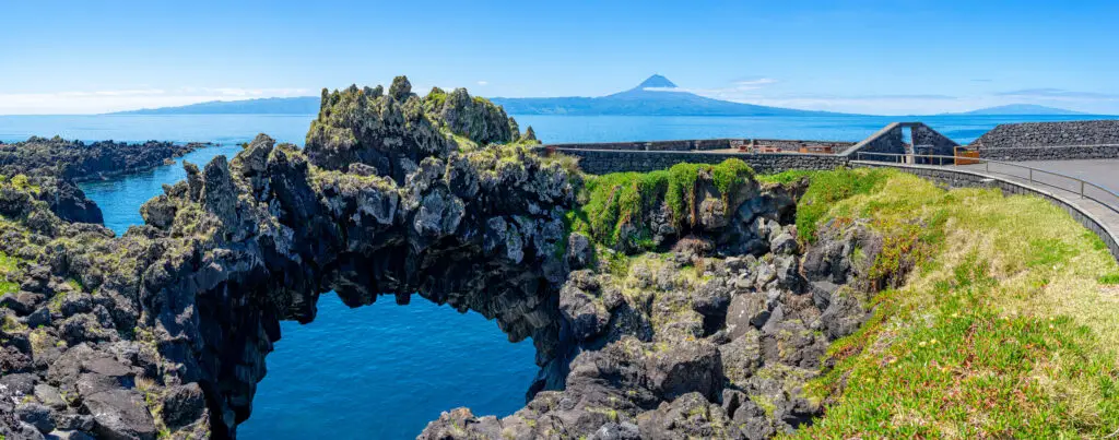 Natural arch of Velas by the Atlantic Ocean with volcanic rock formations and sea view on São Jorge Island, Azores, Portugal