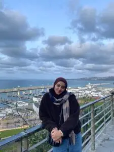 Tourist enjoying the scenic coastal view of a Portuguese harbor with boats and ocean backdrop during a Private Portugal Tour