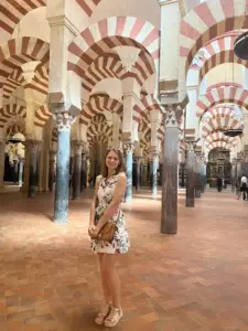 Tourist exploring the stunning interior arches of the Mosque–Cathedral of Córdoba during a Private Portugal Tours experience